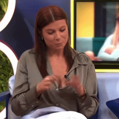 a woman in a green shirt is sitting on a couch and looking down