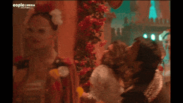 a man kissing a woman in front of a sign that says people + media