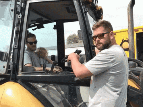 a man wearing sunglasses adjusts the steering wheel of a vehicle