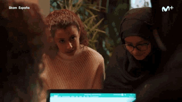 a group of women are sitting in front of a computer screen with the word espana on the bottom