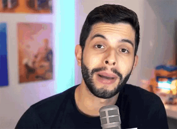 a man with a beard stands in front of a microphone
