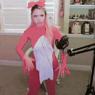 a woman standing in front of a microphone wearing a pink and white outfit