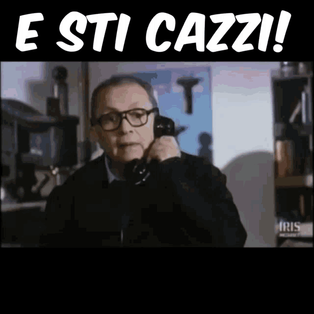 a man talking on a phone with the words " e sti cazzi " written above him