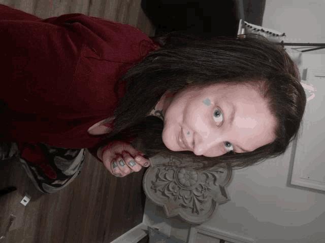 a woman in a red sweater has a blue heart on her face
