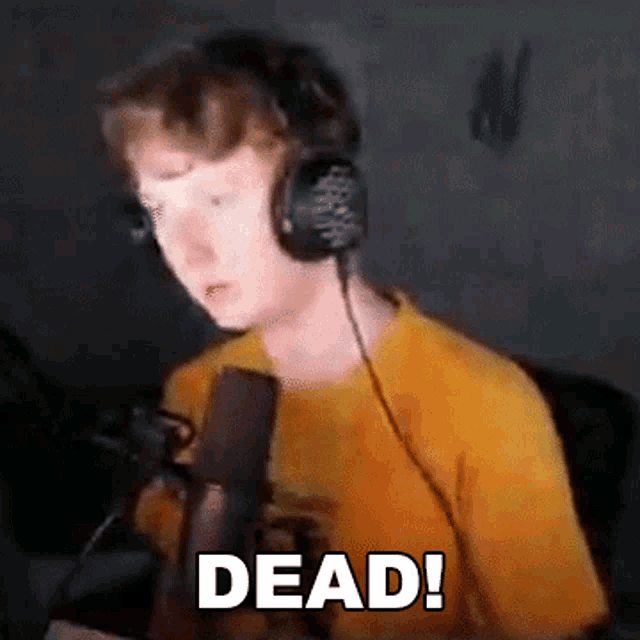a young man wearing headphones is talking into a microphone and says dead !
