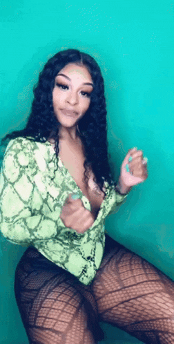 a woman in a green snake print shirt and black tights