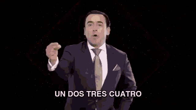 a man in a suit and tie is dancing in front of a diamond shaped background .