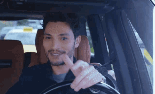 a man is driving a car and making a funny face