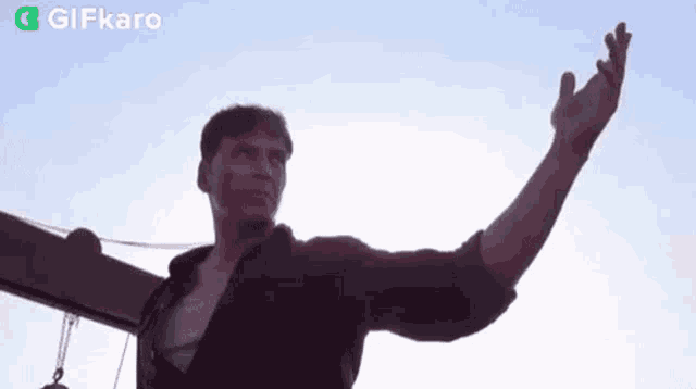 a man is standing in front of a blue sky and giving a peace sign .