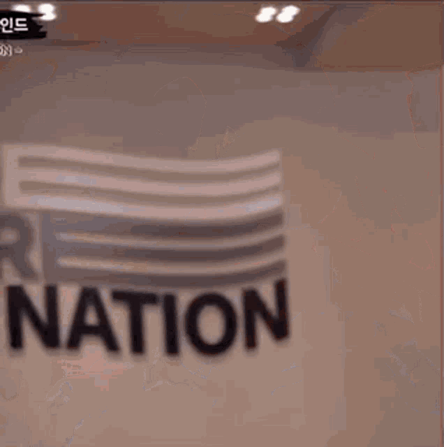 a person wearing sunglasses is making a funny face in front of a sign that says ' tion ' .
