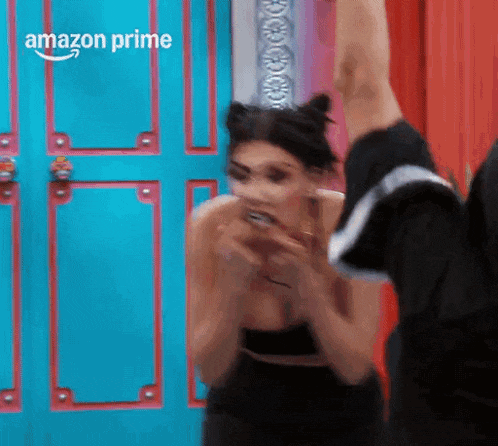 a woman in a black dress is standing in front of a blue door .