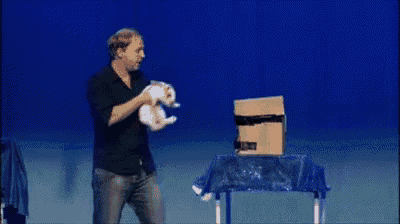 a man is standing on a stage holding a cardboard box