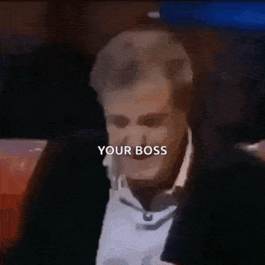 a man in a tuxedo says " your boss " in a blurry photo