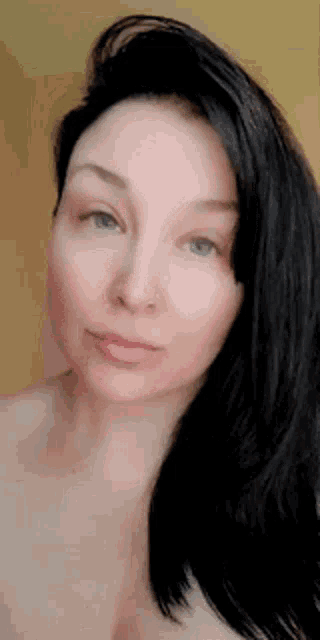 a close up of a woman 's face with long black hair .