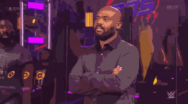 a man stands with his arms crossed in front of a sign that says 206 live