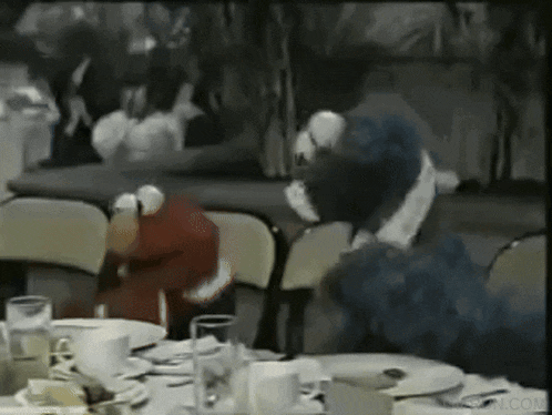 elmo and sesame street characters are sitting at a table with plates and cups
