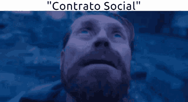 a man with a beard looks up at the sky with the words " contrato social " above him