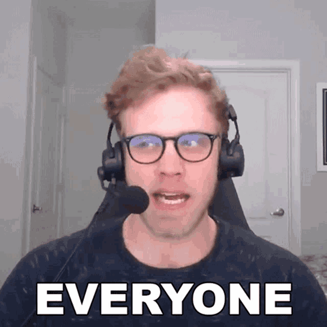 a man wearing headphones and glasses says " everyone "