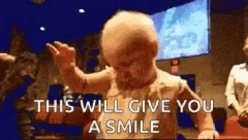 a baby is dancing with the words `` this will give you a smile '' behind it .