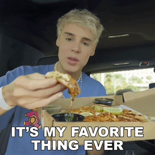 a man in a blue shirt is eating a slice of pizza with the words " it 's my favorite thing ever " behind him