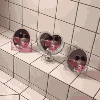 three mirrors are sitting on a tiled floor next to a wall .