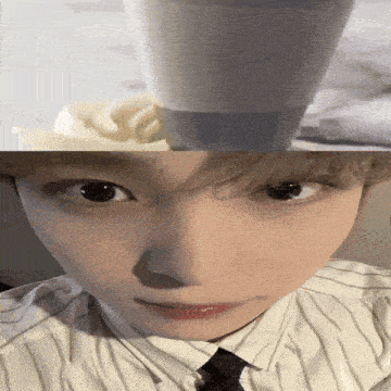 a close up of a person 's face with a cup of milk on top