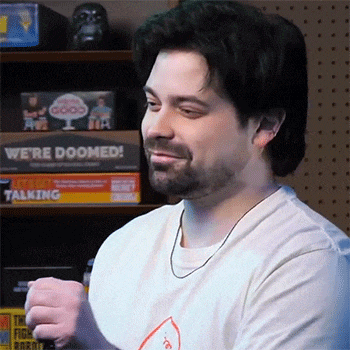 a man with a beard is standing in front of a shelf with a sign that says we 're doomed !