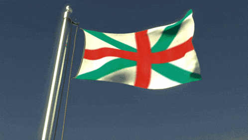 a flag with a red white and green cross is flying in the wind