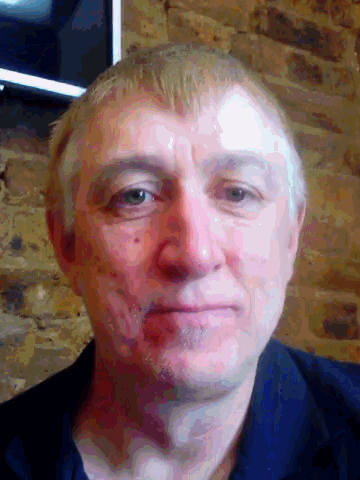 a man 's face is shown in front of a brick wall