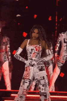 a woman is standing on a stage wearing a newspaper jumpsuit .