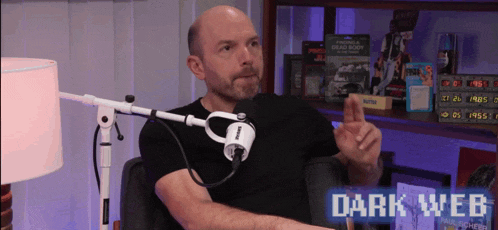 a man is sitting in front of a microphone with the words dark web on the bottom right