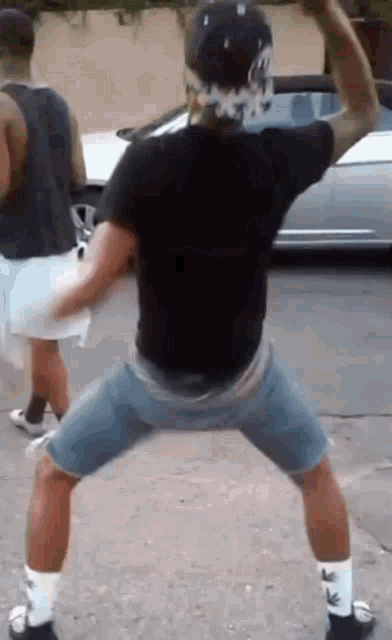 a man in a black shirt and shorts is dancing