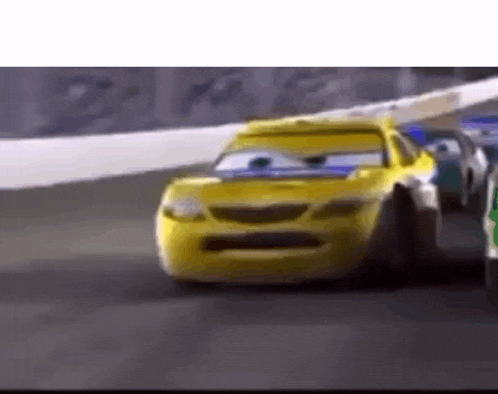 a yellow race car is driving down a race track next to another yellow car .