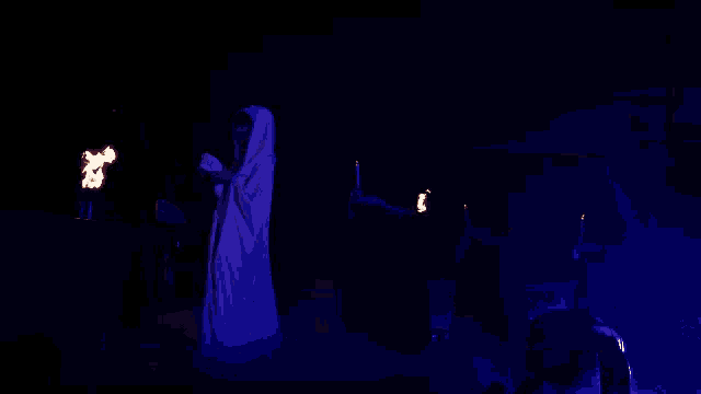 a woman in a white cape is holding a torch