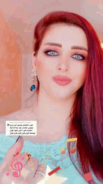 a woman with red hair and blue eyes is wearing a blue top