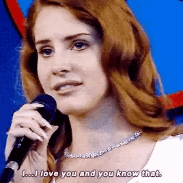 a woman singing into a microphone with the words " i love you and you know that " below her