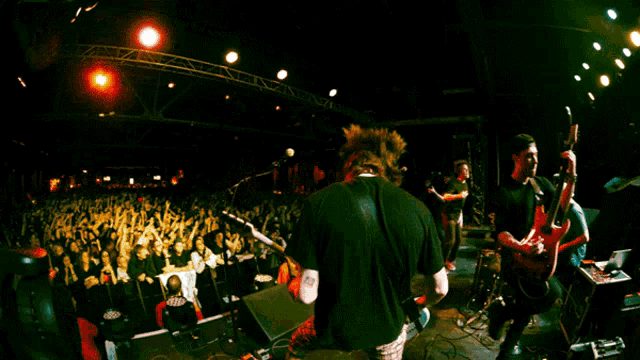 a man playing a guitar in front of a crowd with an x on it