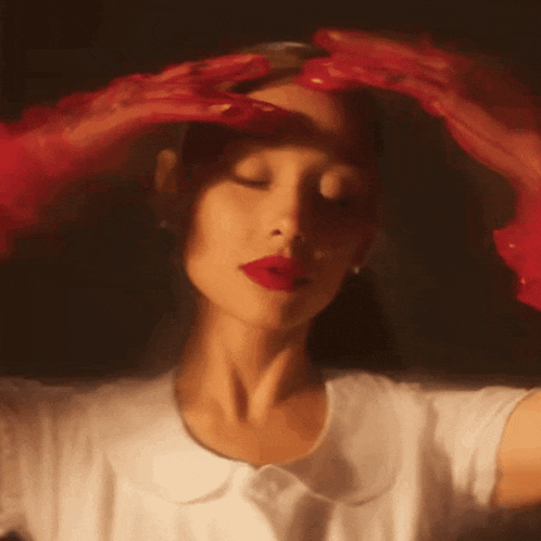 a woman with red gloves covering her face