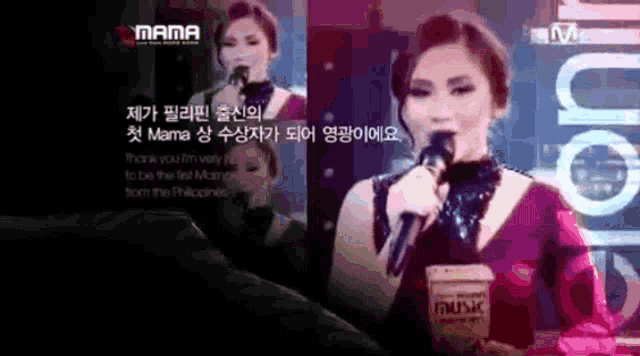 a woman singing into a microphone next to a cup that says music on it