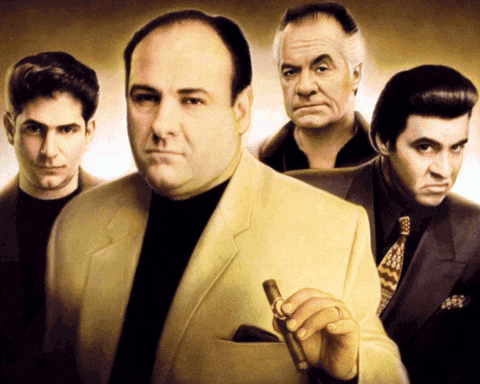 a group of men standing next to each other with one holding a cigar in his pocket
