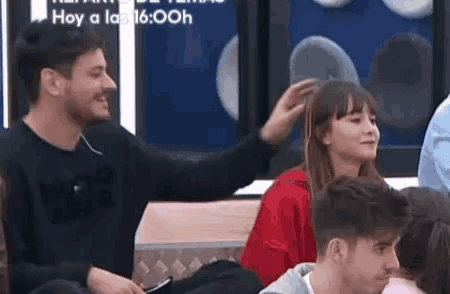 a man is touching a woman 's hair in a room .