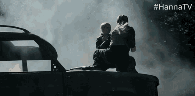 a man and woman are sitting on the back of a car with #hannatv written on the bottom