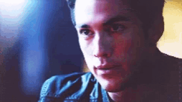 a close up of a young man 's face with a dark background