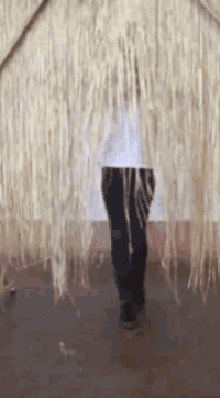 a person is standing in front of a wall of yarn