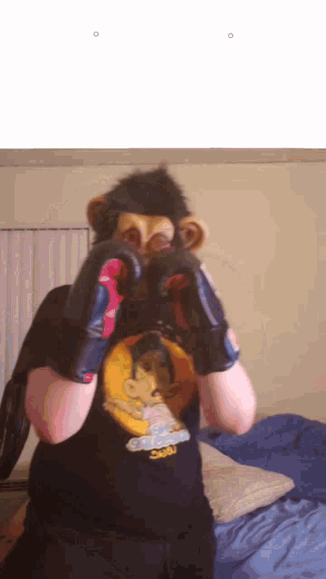 a person wearing boxing gloves and a shirt with a monkey face on it