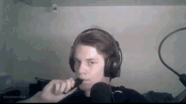 a man wearing headphones is holding a microphone in front of his mouth