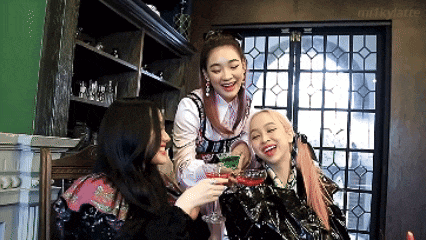 three women toasting with glasses of wine in a room with milkylatte written on the bottom