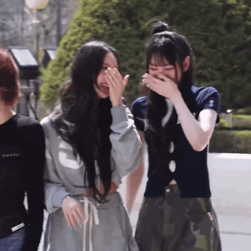 a woman covering her mouth with her hands while laughing