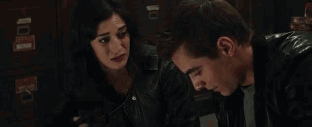 a man and a woman are sitting next to each other in a room .