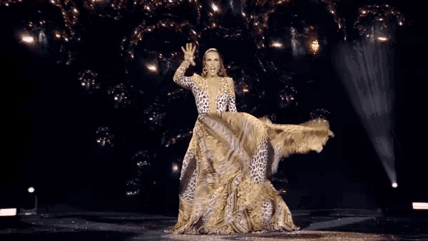 a woman in a leopard print dress is waving her hand